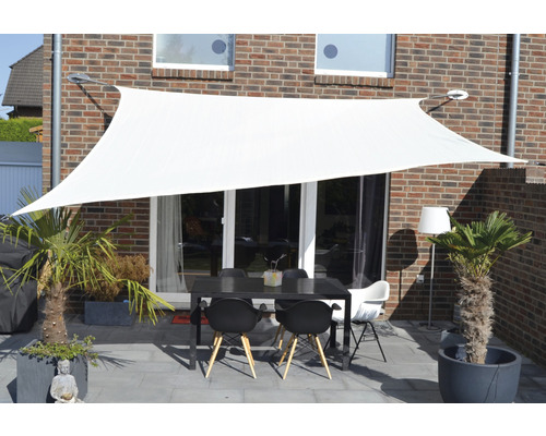 Pânză de umbrire albă deasupra unei terase cu masă și scaune