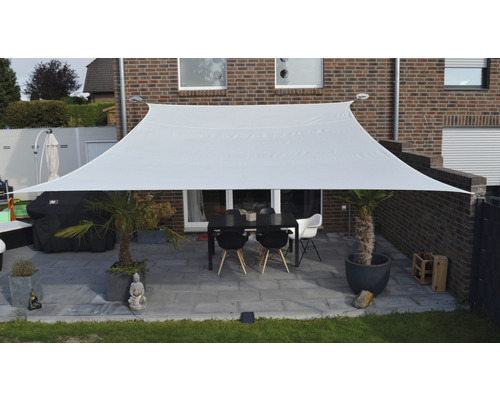 Pânză de umbrire dreptunghiulară din material textil deasupra unei terase cu masă și scaune