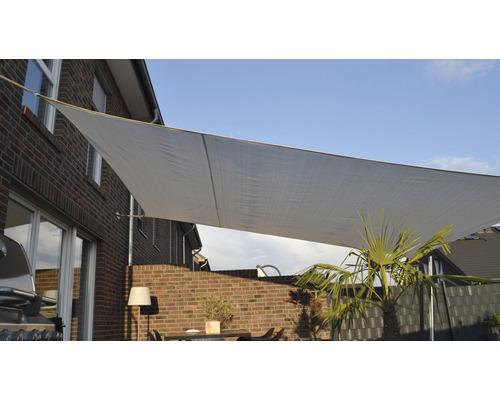 Pânză de umbrire pe o terasă cu mobilier și plante