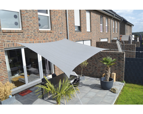 Pânză de umbrire pătrată deasupra unei terase cu masă și plante