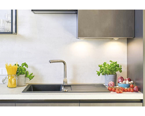 Chiuvetă de bucătărie cu robinet, paste, busuioc și legume pe blatul de bucătărie.