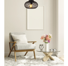 Scenă de living cu fotoliu, măsuță de cafea, decorațiuni și lampă suspendată