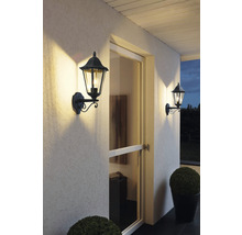 Două aplice decorative de exterior iluminează o zonă de intrare în casă.