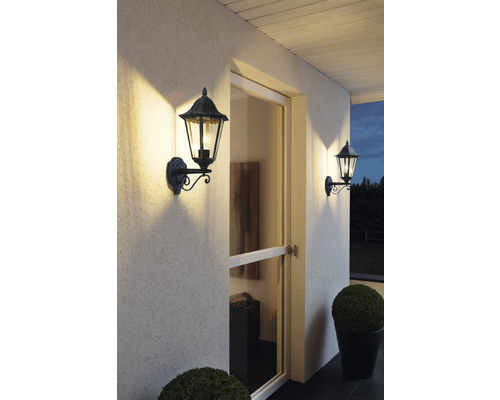 Două aplice decorative de exterior iluminează o zonă de intrare în casă.
