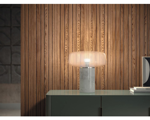 Lampă de masă decorativă din marmură și sticlă pe o comodă în fața unui perete din lemn