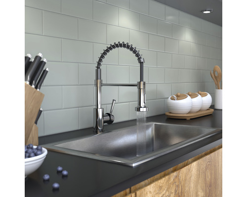 Scenă de bucătărie cu chiuvetă, robinet cu arc spiralat, cuțite și veselă