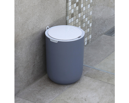 Scenă de baie cu o pubelă rotundă din plastic cu capac