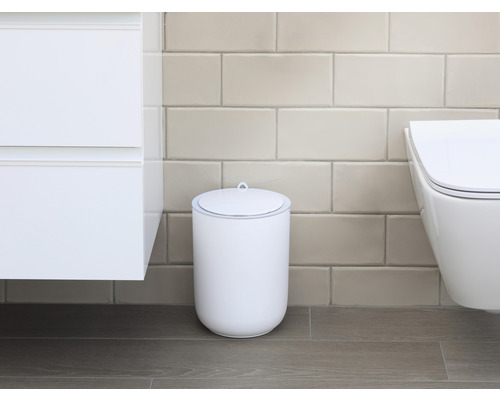 Scenă dintr-o baie cu o pubelă cosmetică albă cu capac