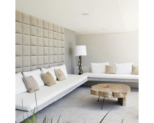 Living luminos cu perne de șezut pe bănci de beton, panouri de perete și masă din lemn