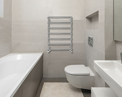 Baie modernă cu cadă, toaletă, chiuvetă și radiator pentru prosoape