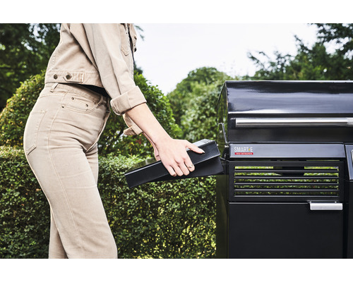 Femeie introducând bateria în grătarul electric.