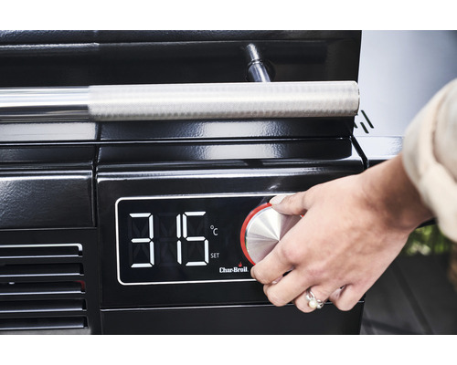 Prim-plan al unui grătar cu afișaj digital al temperaturii, unde o mână acționează butonul