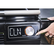 Prim-plan al unui grătar negru cu afișaj digital și controlat de o mână