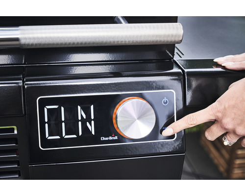 Prim-plan al unui grătar negru cu afișaj digital și controlat de o mână