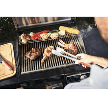 Scenă de grătar cu carne, legume și clește de grătar pe un grătar