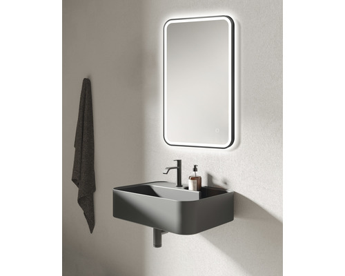 Baie modernă cu lavoar, robinet, oglindă iluminată și prosop