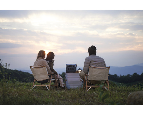 Scenă cu o familie care campează cu o centrală electrică portabilă și mobilier de camping