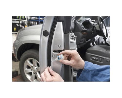 O persoană lipește o garnitură de cauciuc pe o portieră de mașină cu adeziv.