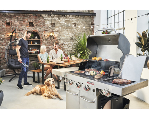 Scenă cu grătar pe cărbune, alimente la grătar și oameni relaxați în aer liber