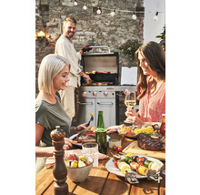 Scenă cu grătar, mâncăruri preparate și trei persoane afară