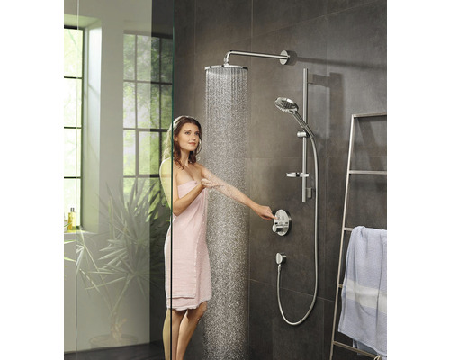 Femeie sub un set de duș cu duș fix și duș de mână într-o baie