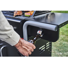 Imagine detaliată cu un grătar pe gaz cu deschizător de sticle în uz