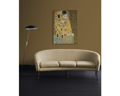 Tabloul Sărutul de Gustav Klimt pe perete deasupra unei canapele