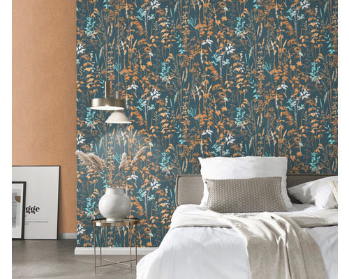 Dormitor cu tapet cu model floral, pat și veioză.