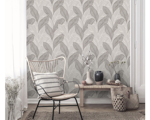 Cameră de zi cu tapet cu model de frunze, scaun și decorațiuni pentru o ambianță elegantă