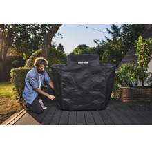 Un bărbat fixează o husă de grătar Char-Broil pe o terasă