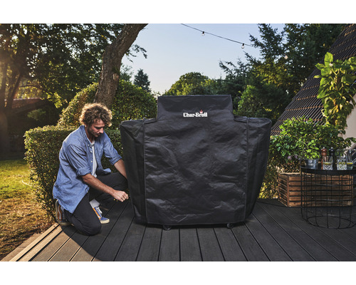 Un bărbat fixează o husă de grătar Char-Broil pe o terasă