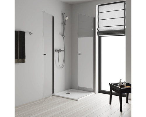 Cabină de duș cu uși din sticlă, armătură de duș și suport pentru prosoape în baie luminoasă