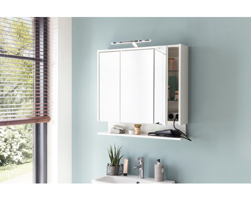 Baie modernă cu dulap cu oglindă alb, raft și iluminat deasupra unei chiuvete.