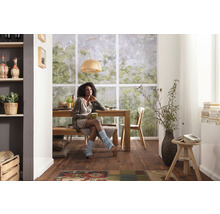 Zonă de luat masa luminoasă cu masă din lemn, bancă, scaune și o femeie.