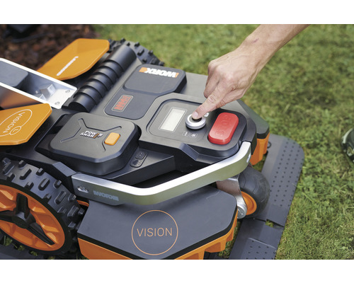 O persoană operează o mașină de tuns iarba robotizată.