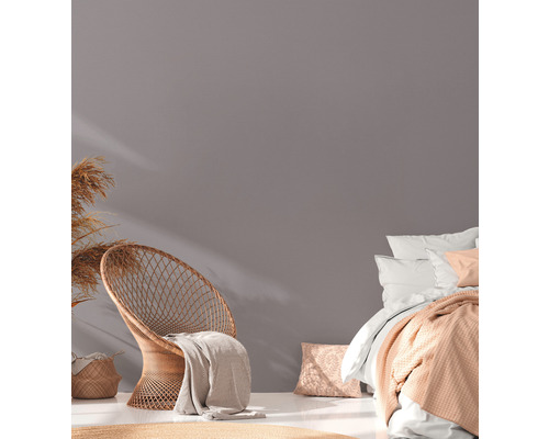 Cameră luminoasă cu fotoliu din ratan, pat și decorațiuni pentru o atmosferă confortabilă.
