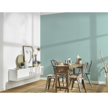 Sufragerie cu masă din lemn, scaune și raft de perete cu decorațiuni în fața unui perete colorat