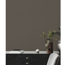 Interior decorativ cu un dulap negru, plante, obiecte de artă și un teanc de cărți