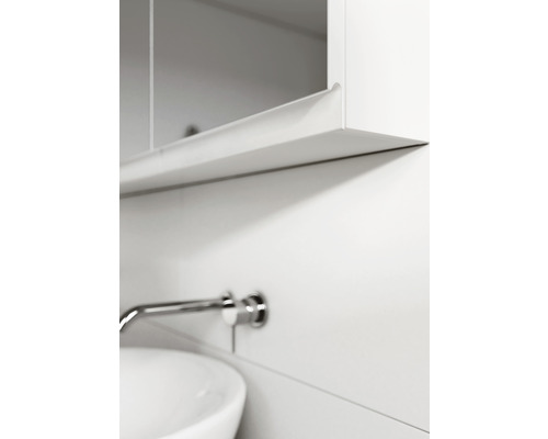 Prim-plan al unei băi cu chiuvetă, robinet și dulap cu oglindă