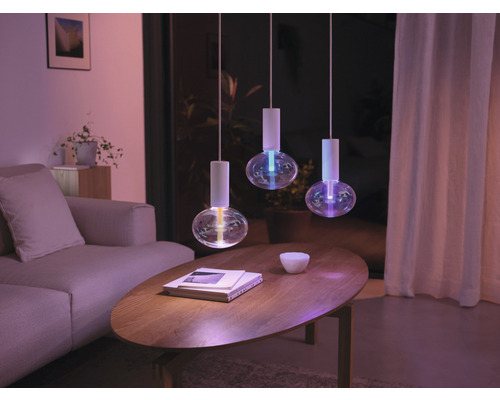 Cameră de zi cu trei lumini suspendate deasupra unei mese