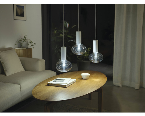 Scenă cu trei lămpi suspendate deasupra unei măsuțe de cafea într-o sufragerie