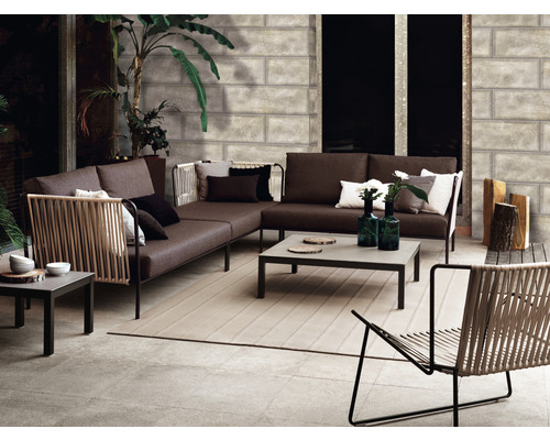 Scenă cu mobilier de grădină: canapea de colț, fotoliu și masă pe o terasă.