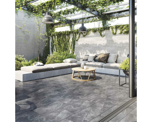 Spațiu exterior amenajat cu zonă de relaxare sub o pergolă cu vegetație