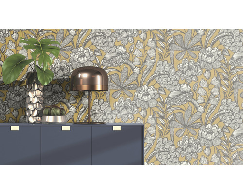 Scenă decorativă cu tapet floral, comodă, lampă, vază și cactus