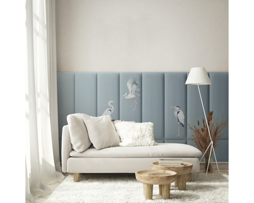 Living cu canapea, perne, măsuțe laterale, lampadar și panouri de perete cu motive de păsări pentru o atmosferă luminoasă și organizată.