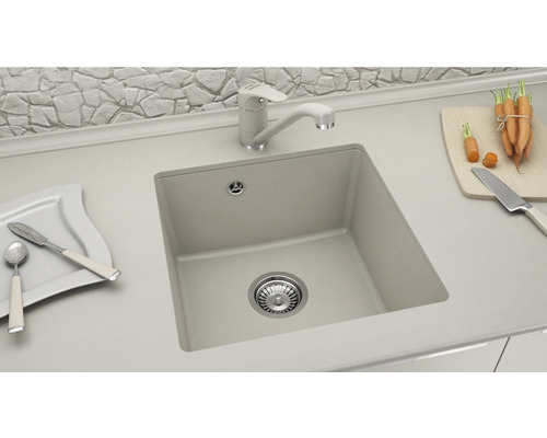 Scenă de bucătărie cu chiuvetă, robinet, veselă, tocător cu morcovi și cuțit pe un blat de lucru