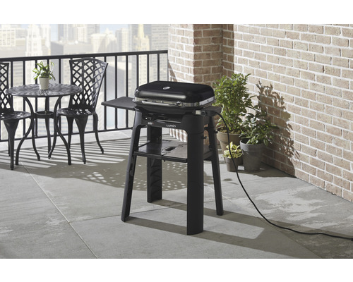 Grătar electric pe un balcon cu masă și scaune.