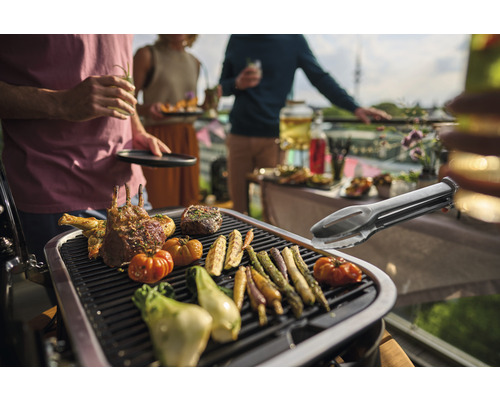 Scenă de grătar cu carne, legume și clește de grătar pe un grătar la o petrecere în grădină