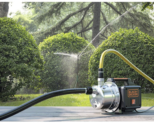 Scenă de irigare a grădinii cu o pompă centrifugă Black plus Decker care alimentează un aspersor de gazon