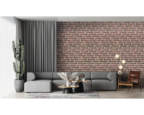 Living cu tapetă de cărămidă, canapea gri și plantă de apartament